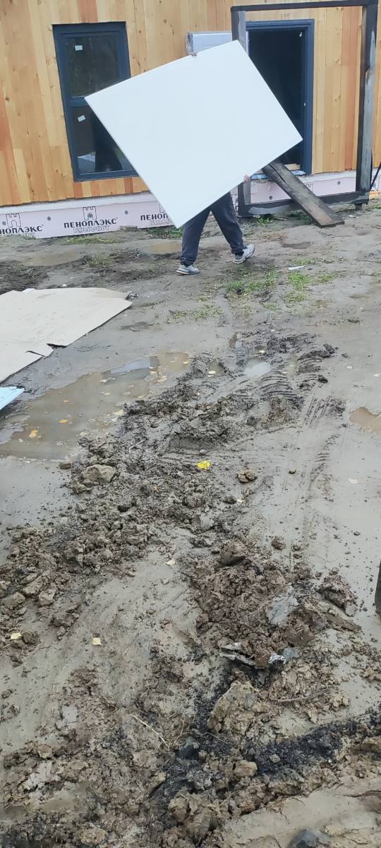 Заносим лист гипсокартона в дом через открытую дверь